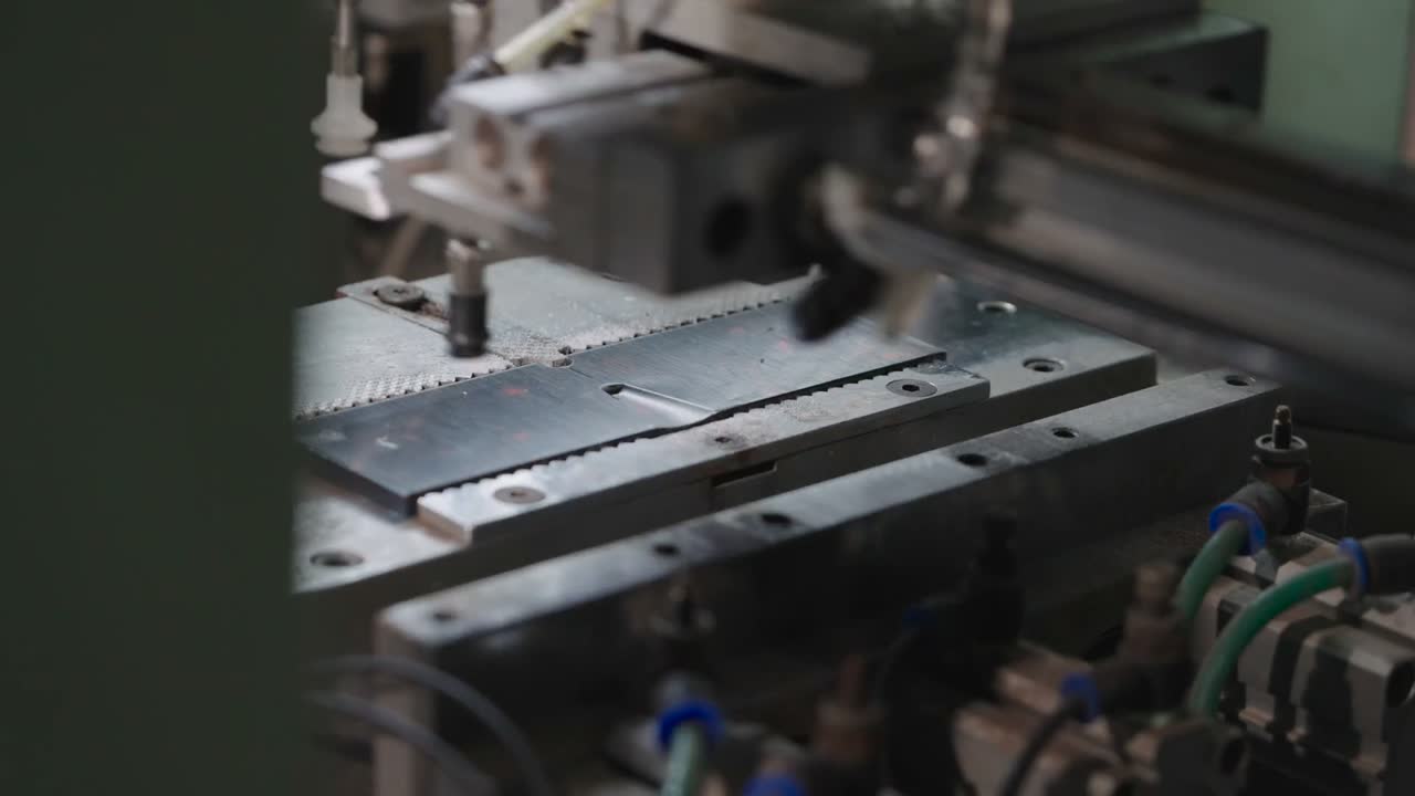 A press closes on a frame front to bond the nose pads.