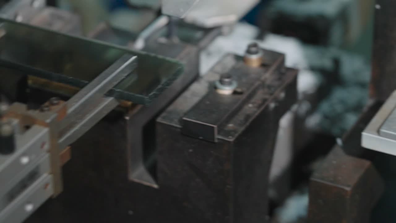 Brass tooling in a press, used to form the bridge of a frame.