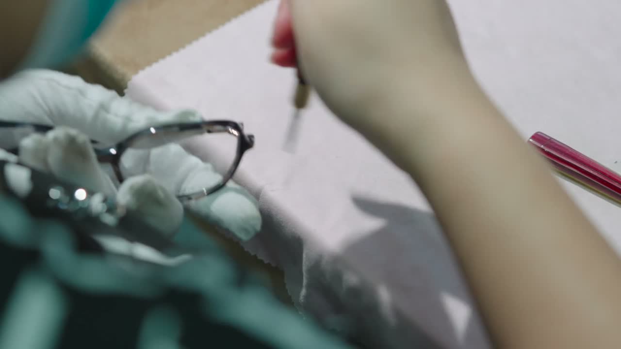 A worker rivets a hinge into a frame at a bench.