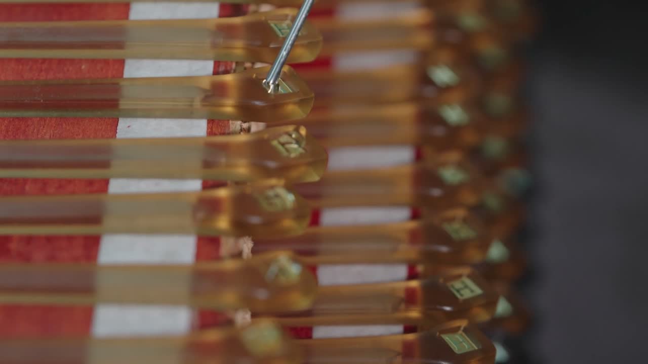 A rack of temples with metal logo plates, being filled with epoxy.