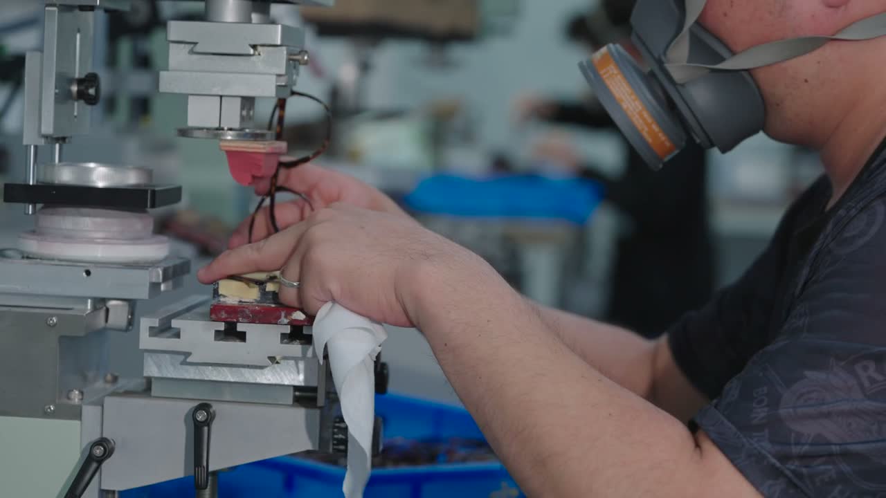 A pad printing machine applies markings to the inside of a temple.