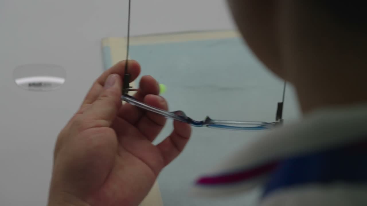 A worker assembles a finished frame at a white bench laid out with parts.