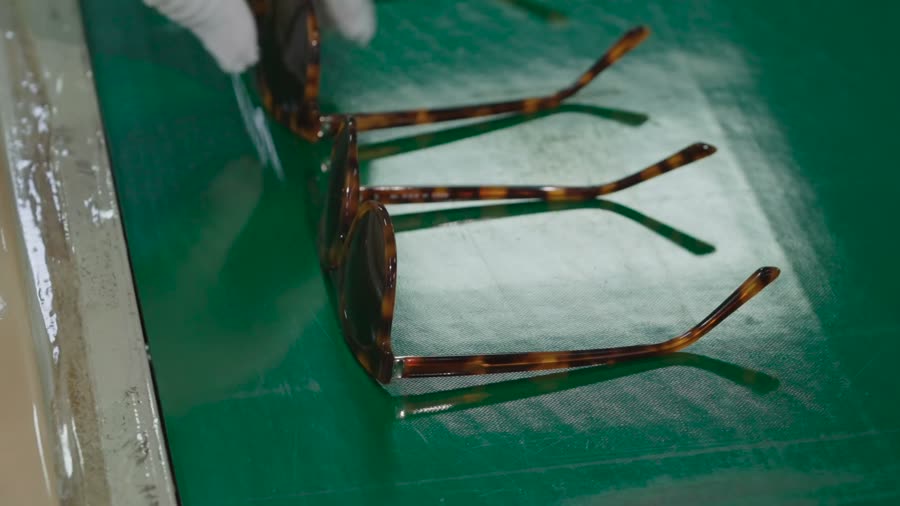 A finished frame held over a technical drawing during inspection.