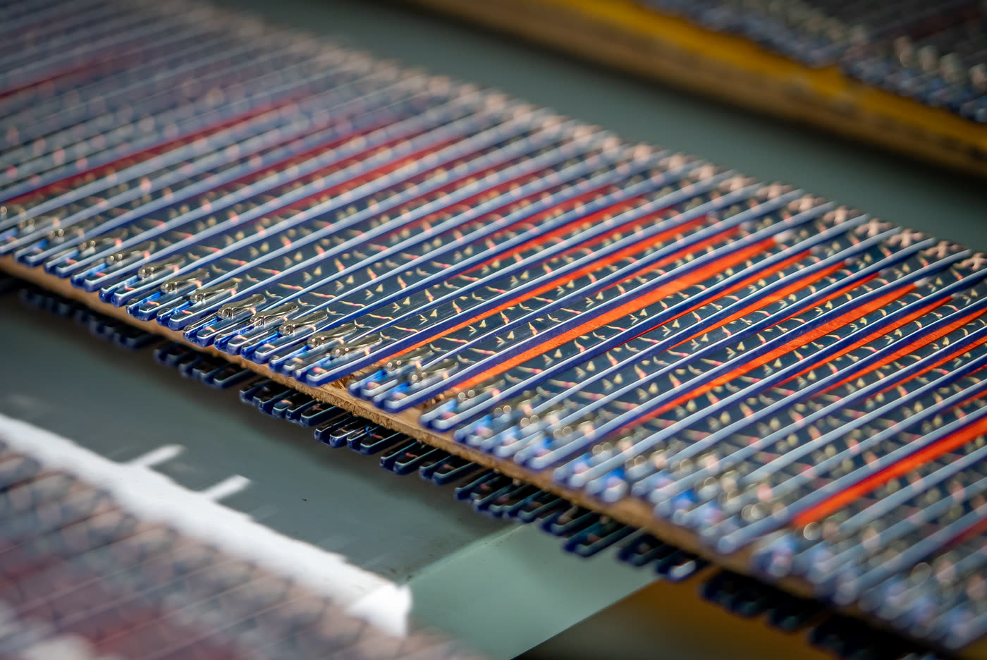 Rows of eyewear fronts clamped in a wooden rack, lit in blue and orange.