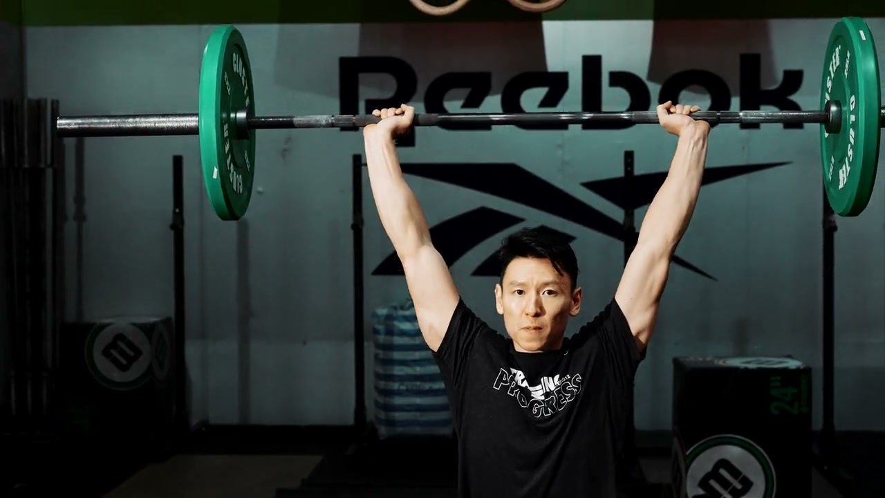 A lifter mid-set in a dark gym.